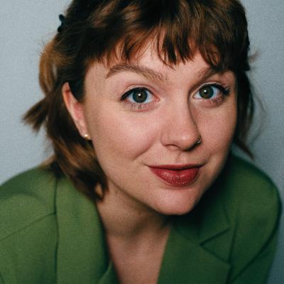 woman with brown hair in a green blazer