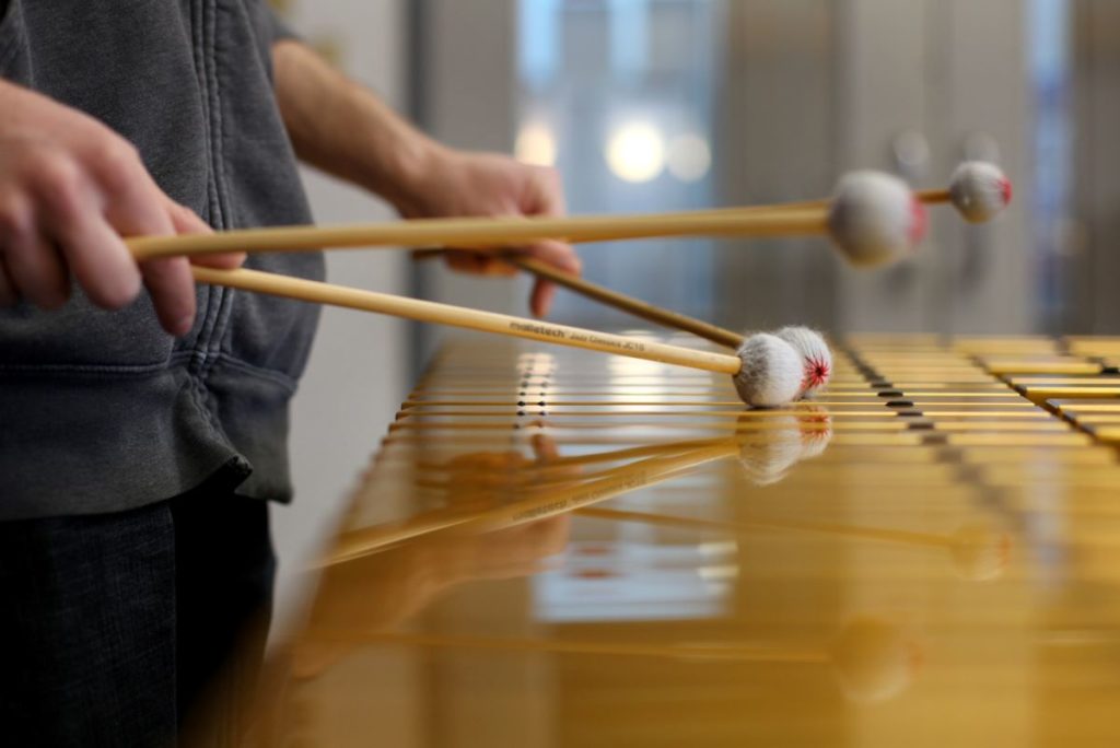 close up of the h和s of a student playing the xylophone
