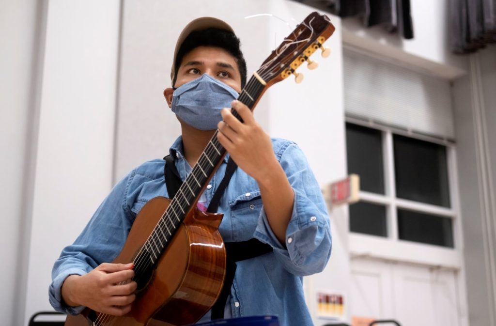 student playing the guitar during LUME rehearsal