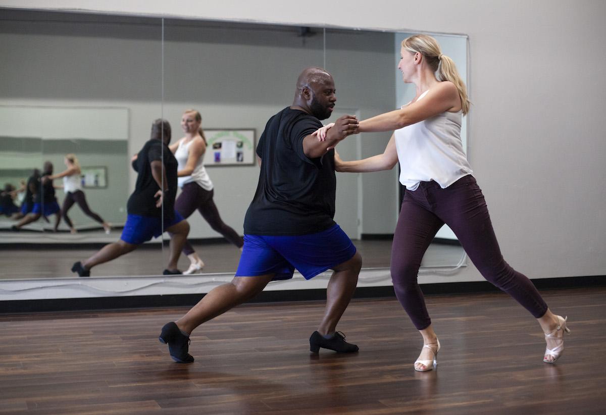 Jesus Smith rehearses with Pamela Cribbs in front of a mirror 