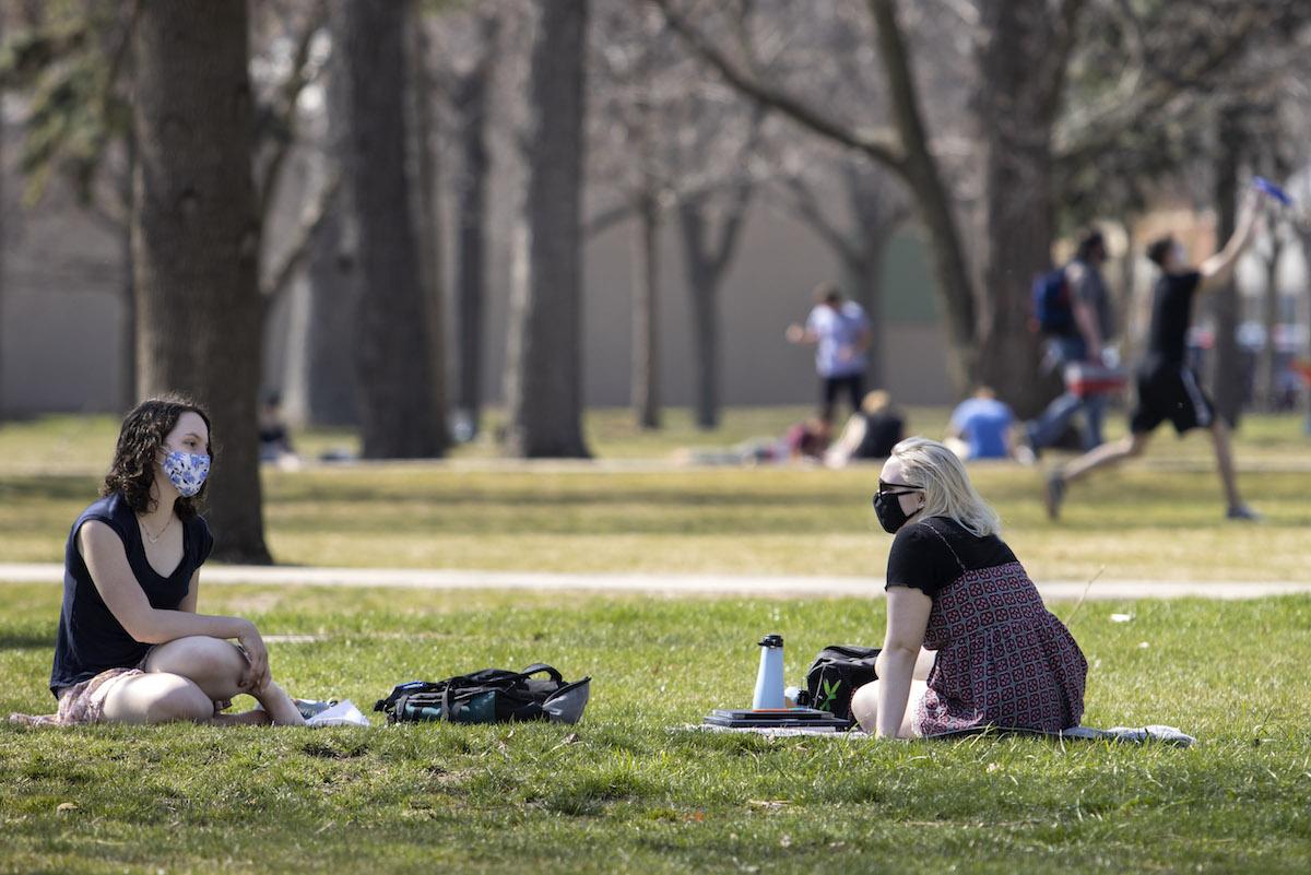 Students with masks talking in Main Hall Green 
