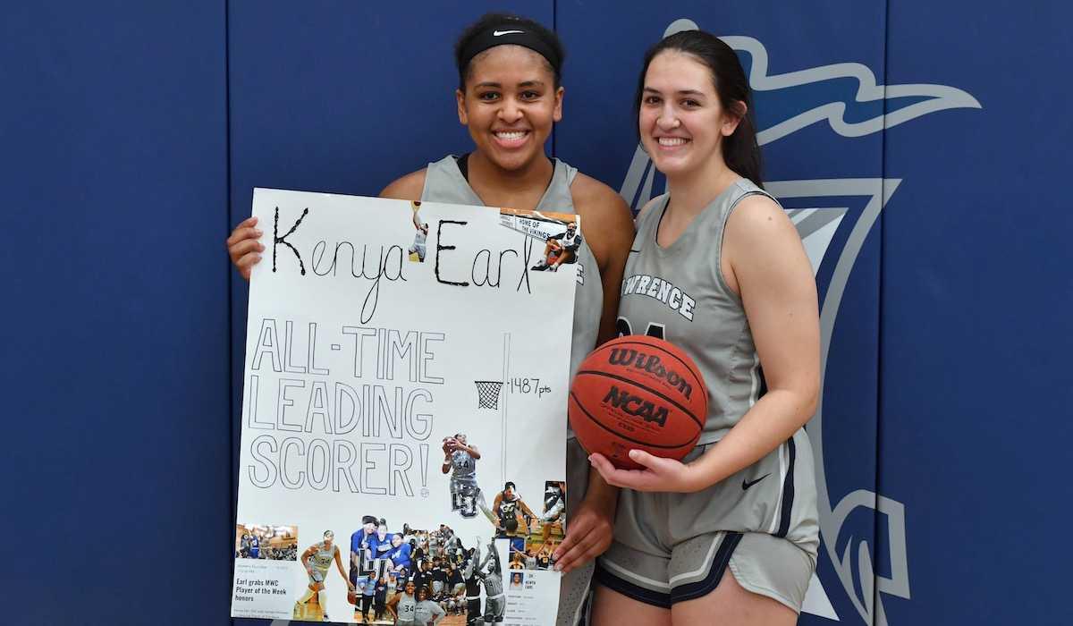 Kenya Earl stands with 卡琳娜Herrera while holding a handmade sign that says All Time Leading Scorer.