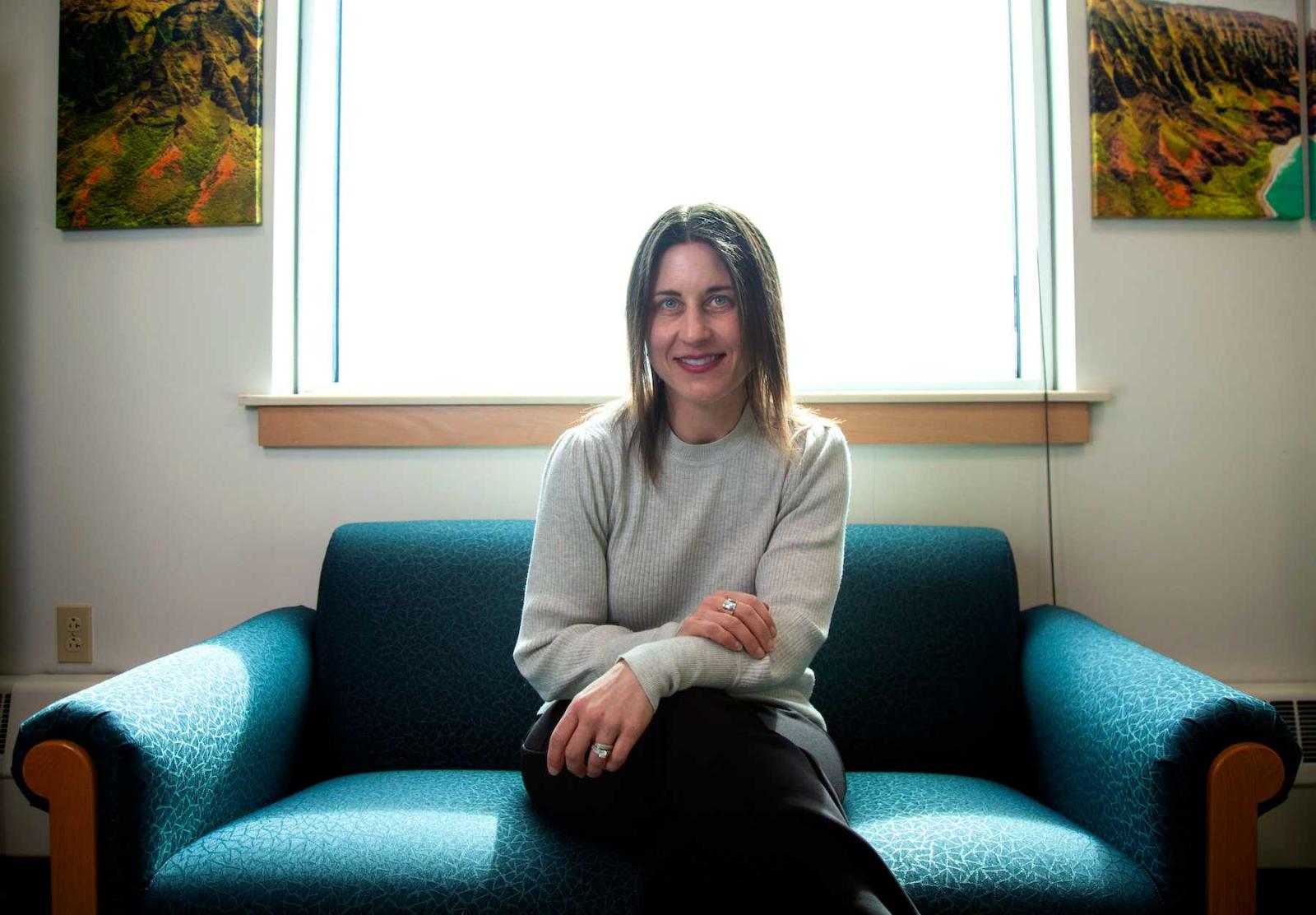 Professor Lori Hilt sits on a chair in her office as she poses for a portrait.
