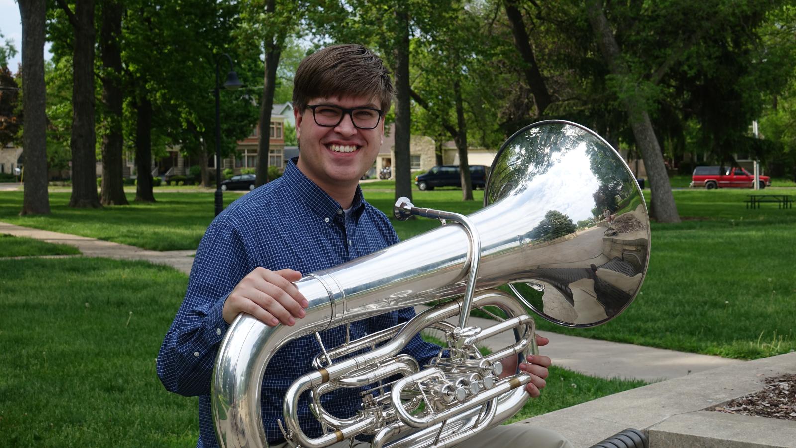 Henry holds a tuba.