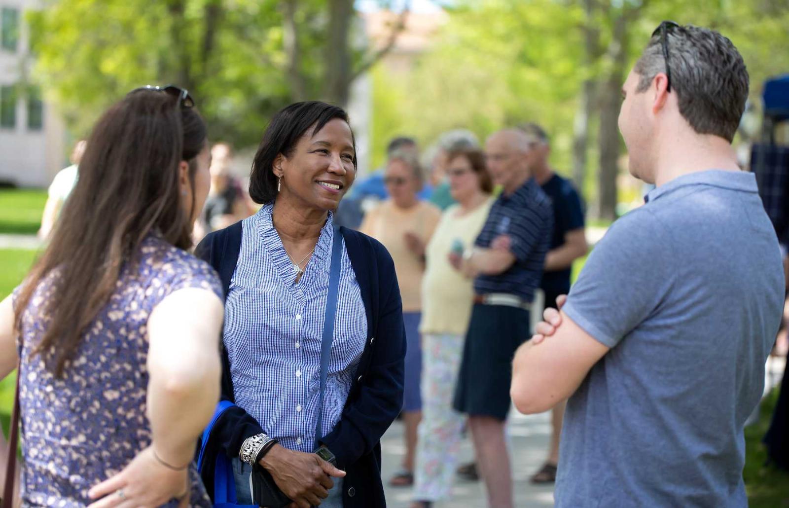 President Laurie A. Carter talks with two people at the Brighter Together Picnic.