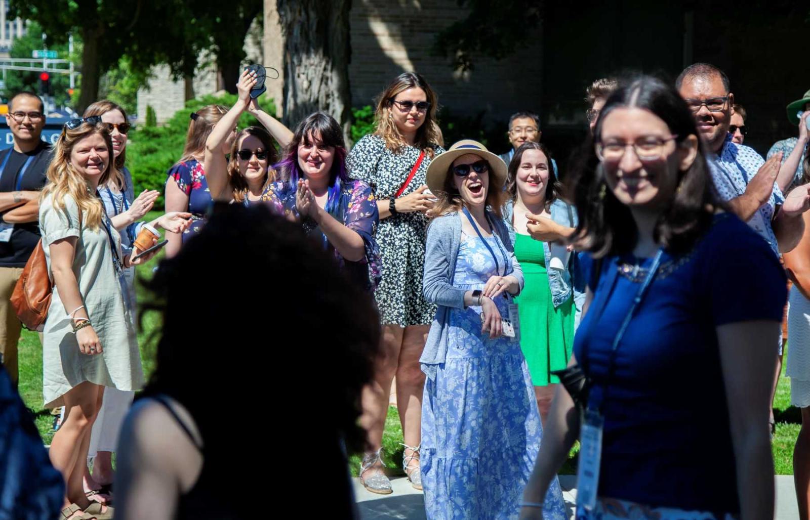 A group of alumni smile and applaud during the Parade of Classes.