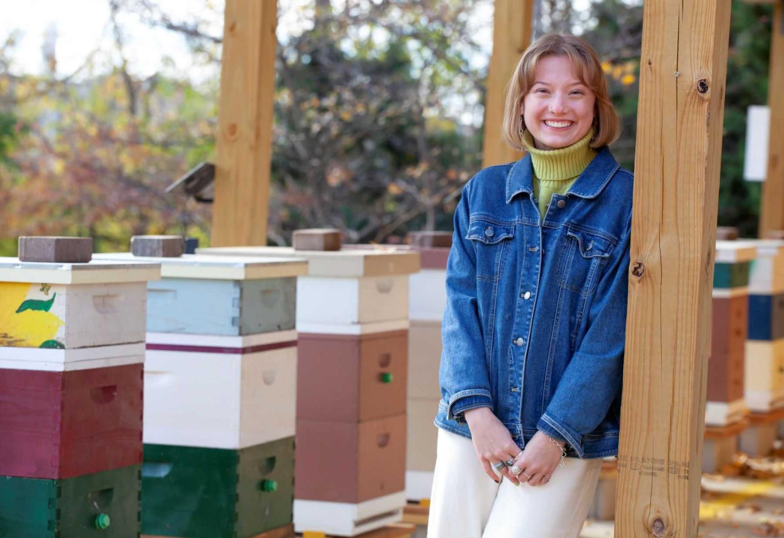 生物学 major, Bella Goland poses for a photo in the apiary in Sustainable 劳伦斯大学 Garden.