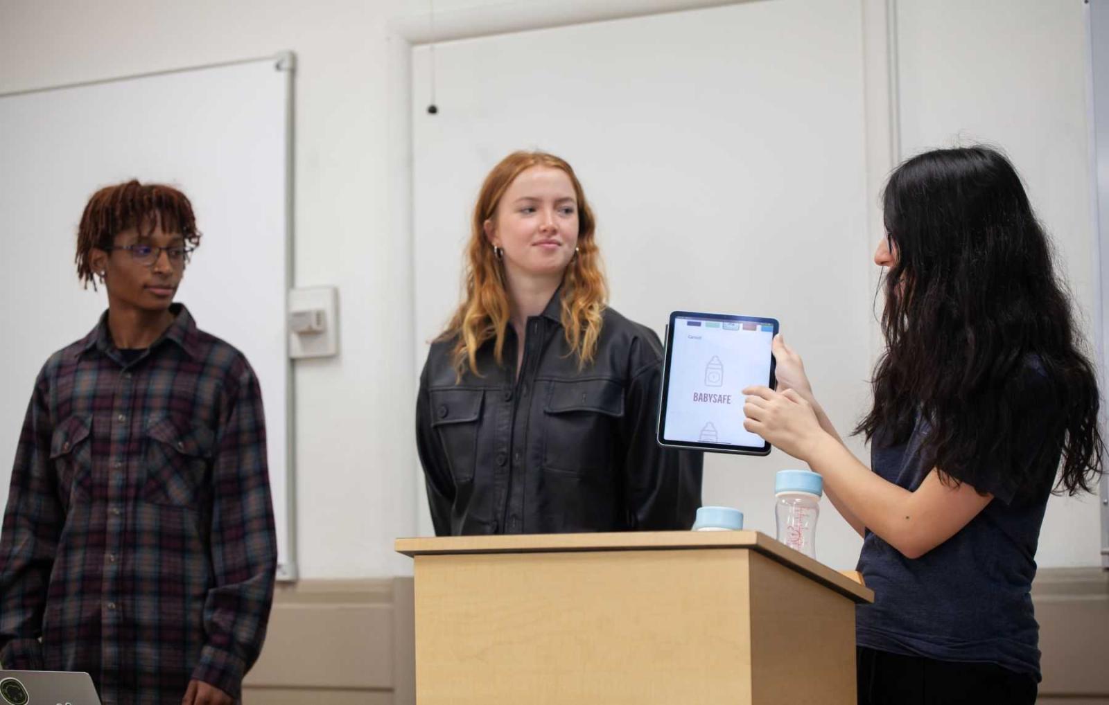 Senior Kate Oztunc shows a screen and talks as classmates look on during their Innovation & Entrepreneurship class. 