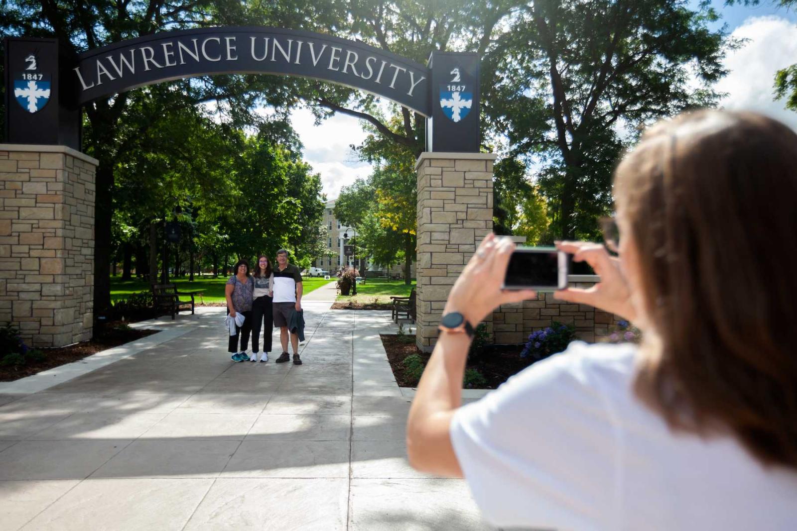 Savannah Betterley, a first-year student, poses for a photo under the Lawrence Arch with her parents during Welcome Week in September.