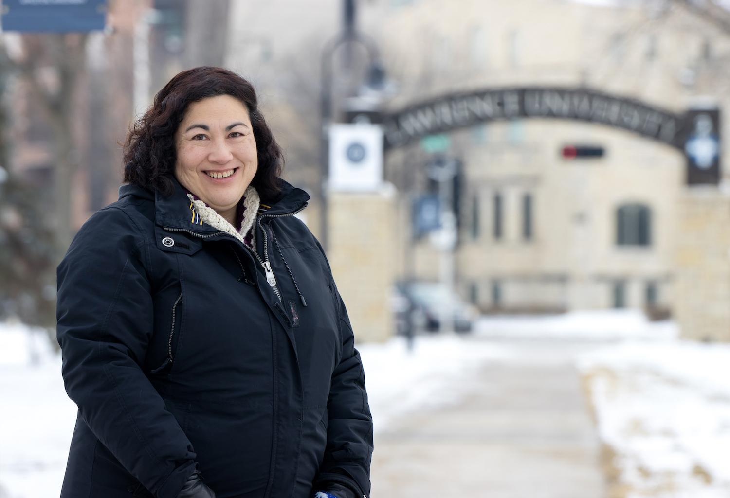 Monica Rico poses for a photo on the sidewalk leading to Main Hall.