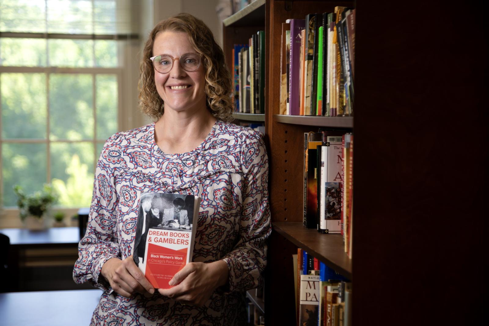 Betsy Schlabach holds a copy of her book, Dream Books and Gamblers