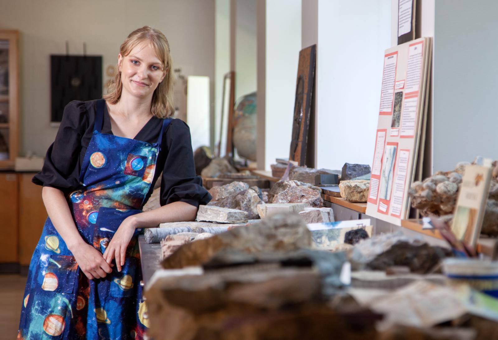 Sydney Closson poses amid a collection of rocks in Youngchild Hall.