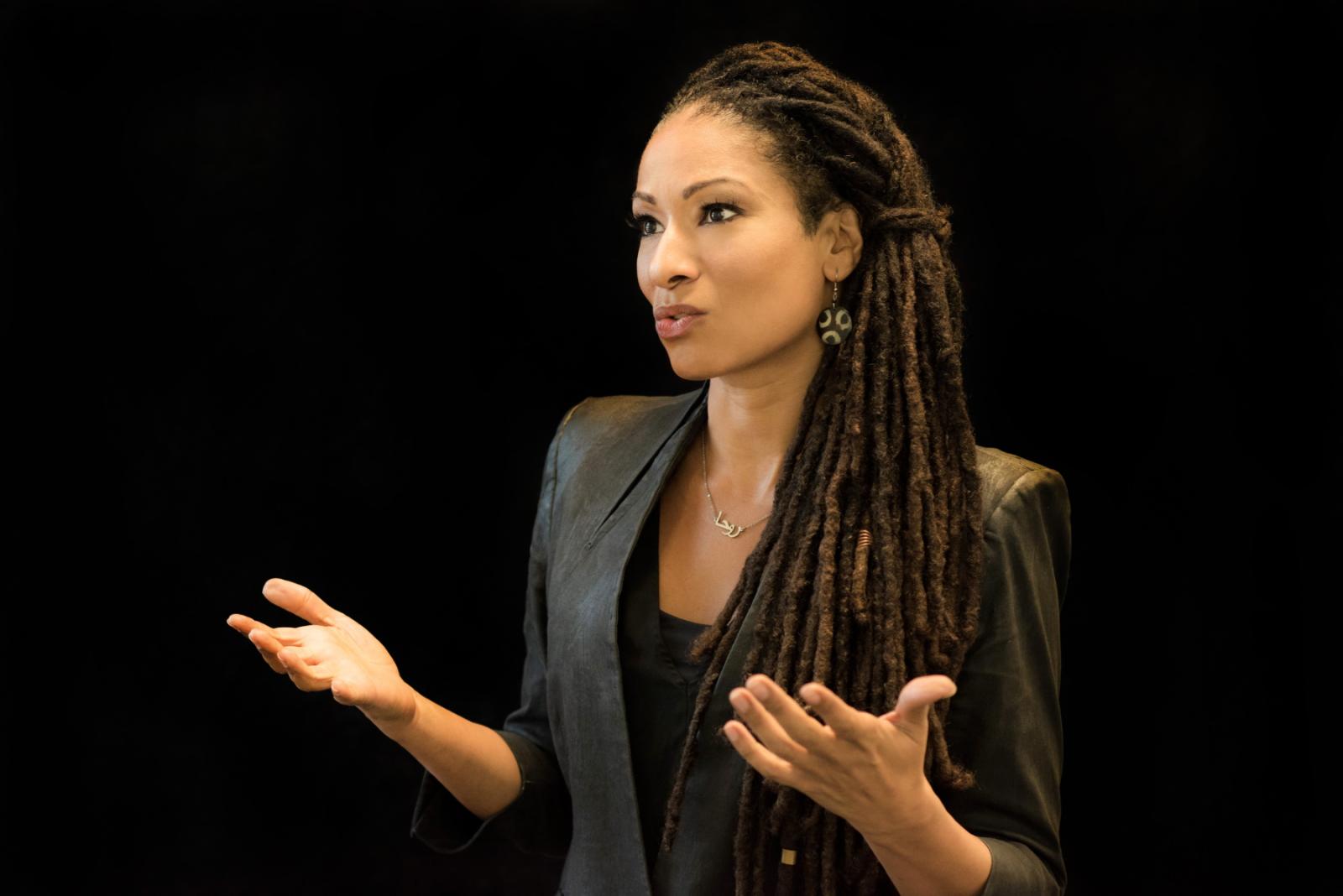 Ruha Benjamin gestures as she speaks to an audience.