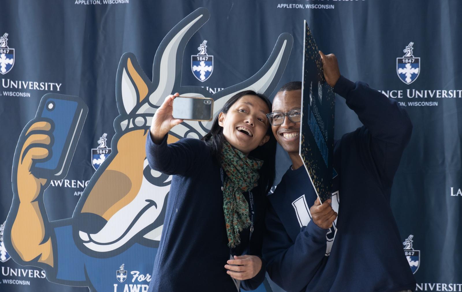 Students and alumni take selfies together during the 2023 Forever a Lawrentian events. 