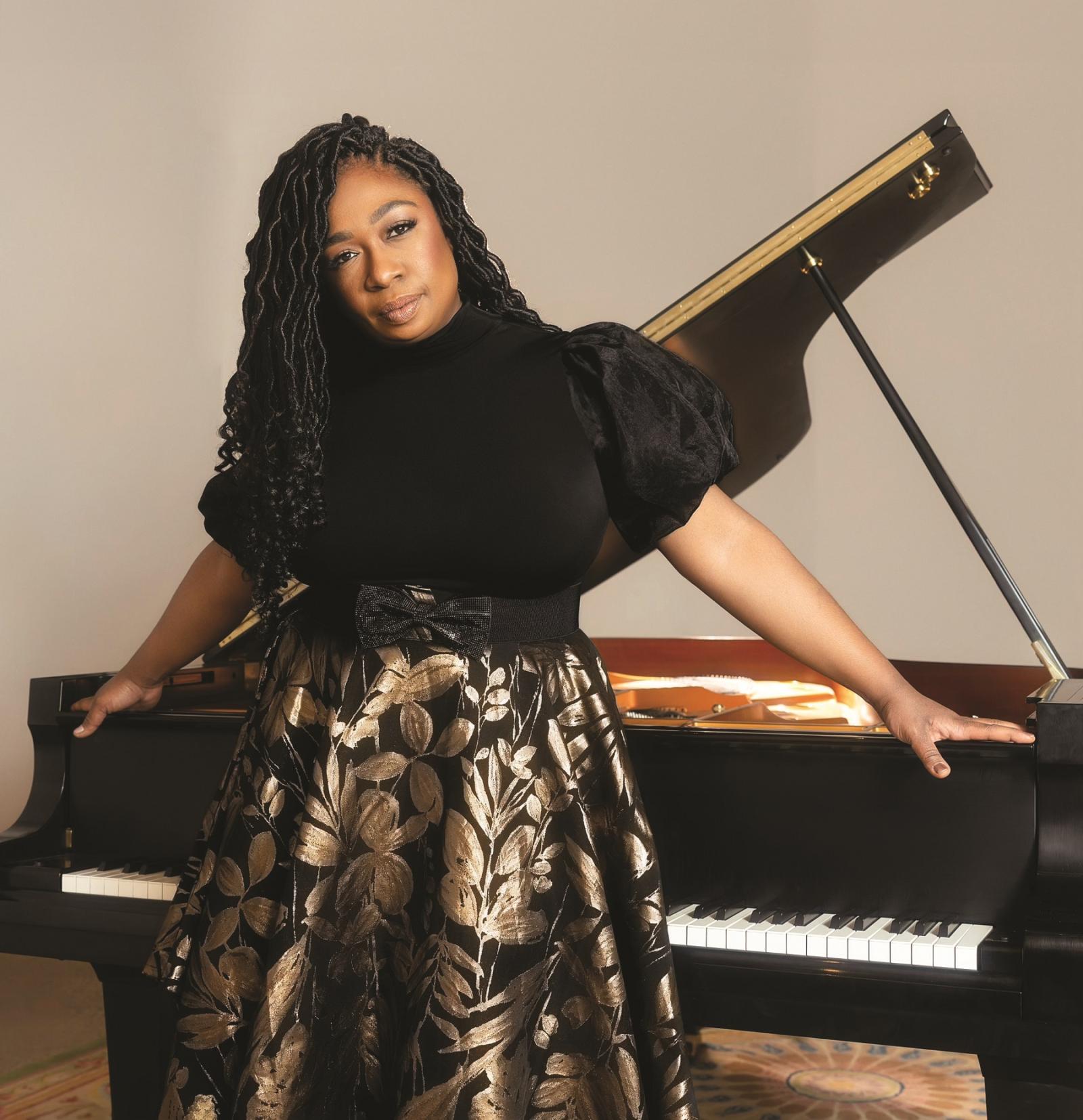 米歇尔还 poses for a photo in front of a piano.