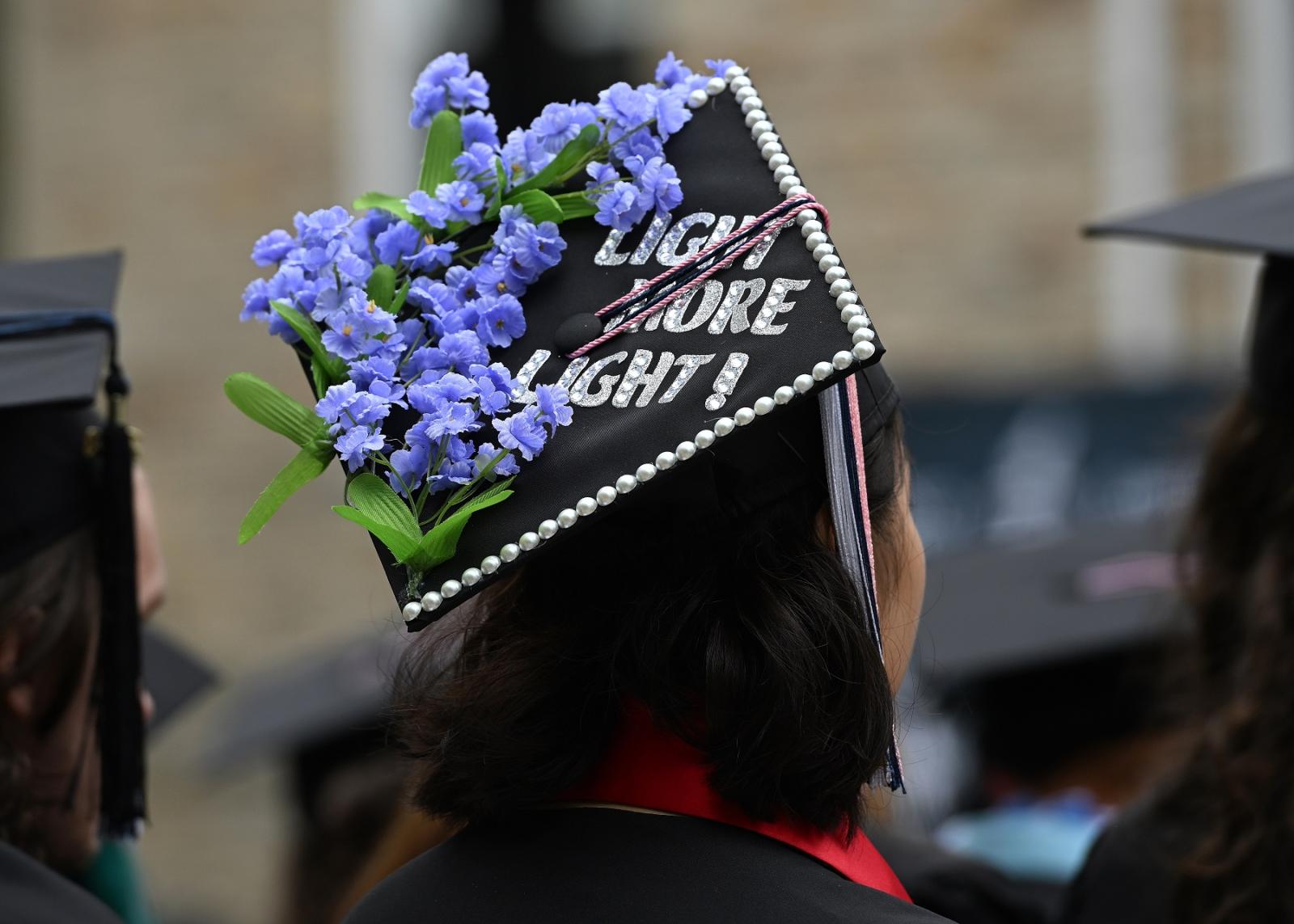 A graduation cap is adorned with Light More Light!