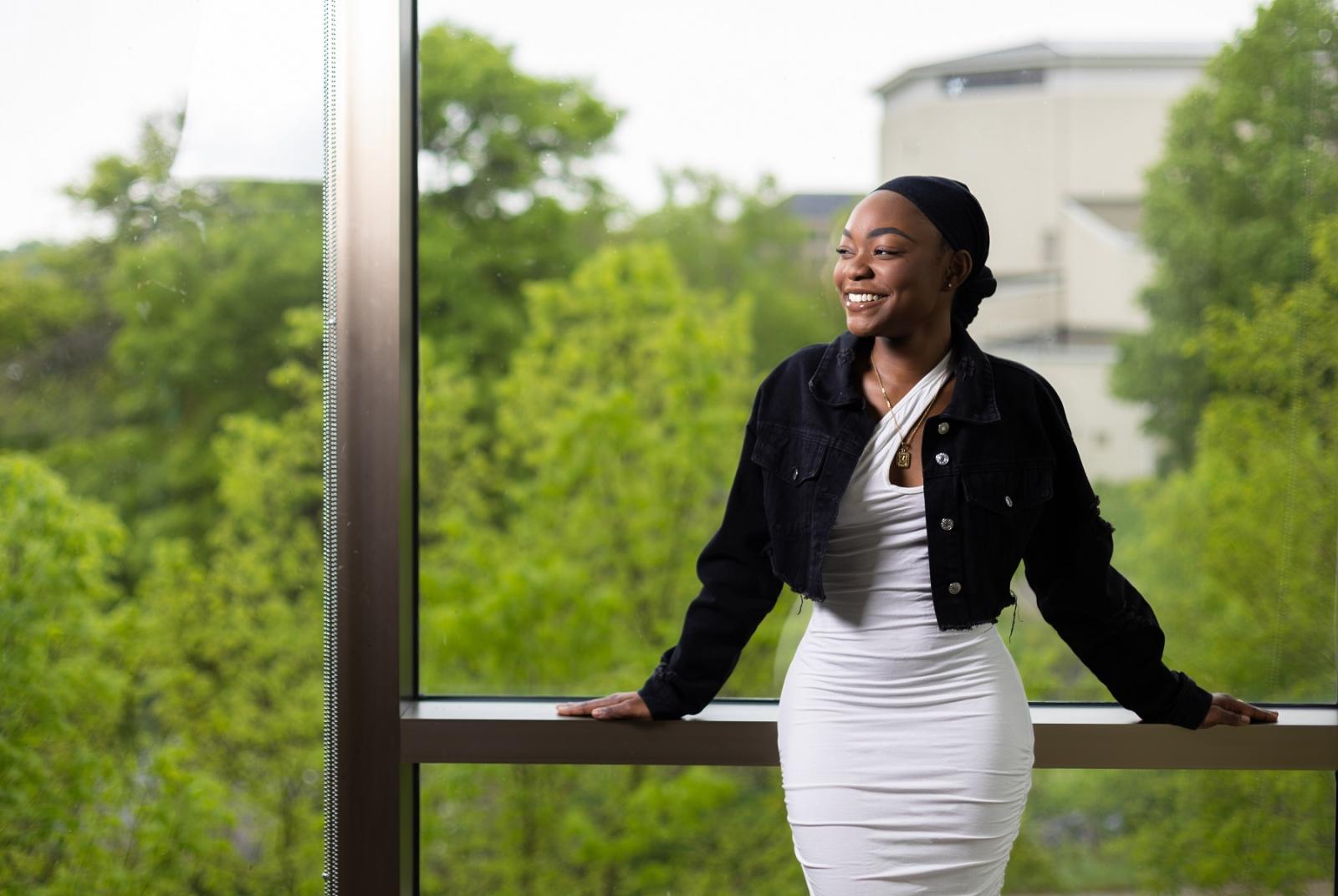 Monique Johnson poses for a portrait in front of the large windows in Warch Campus Center.