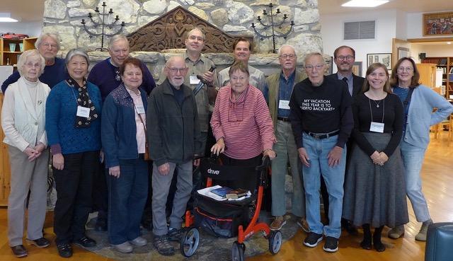 seminar guests pose in front of a stone fireplace
