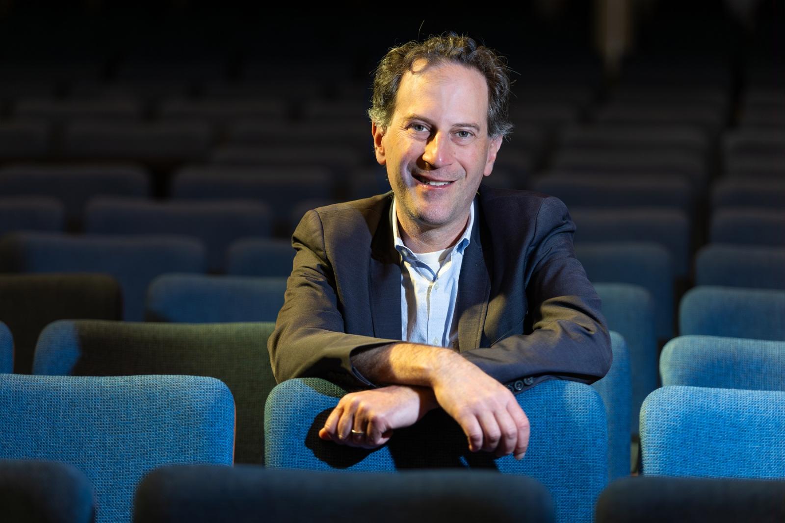 Michael Mizrahi poses for a photo in the seats of Memorial Chapel.