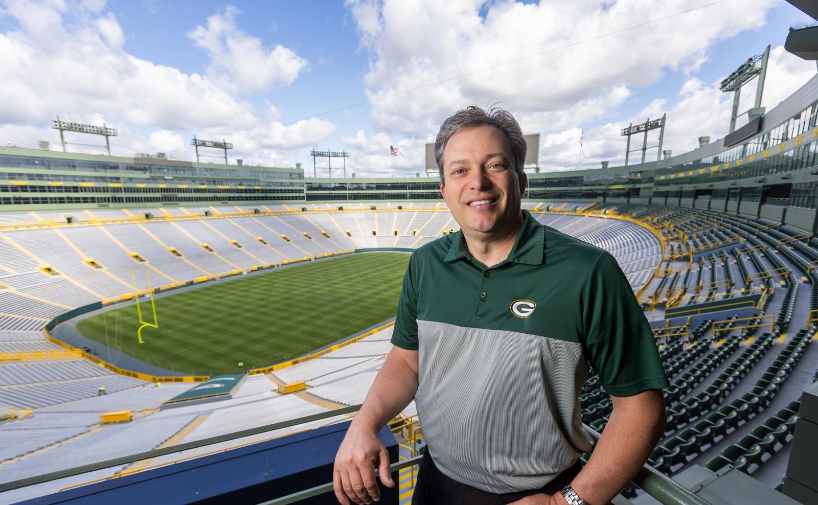 Mike Spofford '94 poses for a photo inside Lambeau Field. 