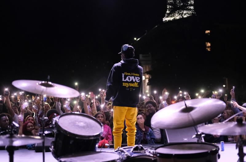 A student performs on stage in front of Main Hall
