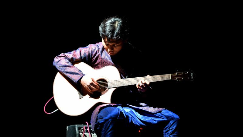 Student playing guitar at Cultural Expressions.
