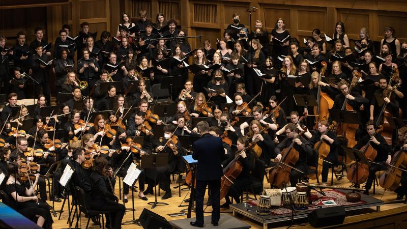 Full orchestra and choir in concert black dress fill the stage of the Lawrence Chapel during the Master Work Concert