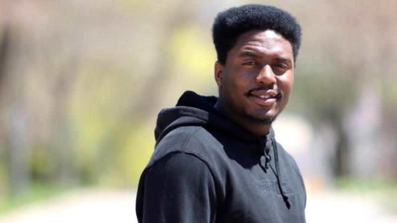 Oryan Brown, wearing a black hoodie, smiles at the camera.