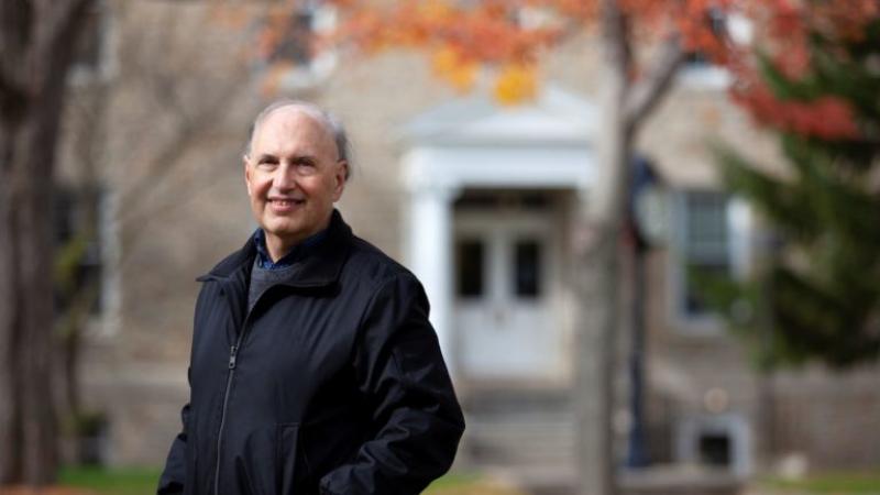 Jerald Podair, wearing a black coat, smiles at the camera.