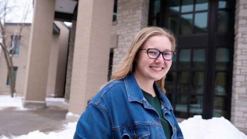 Molly Ruffing, wearing a jean jacket, smiles at the camera.