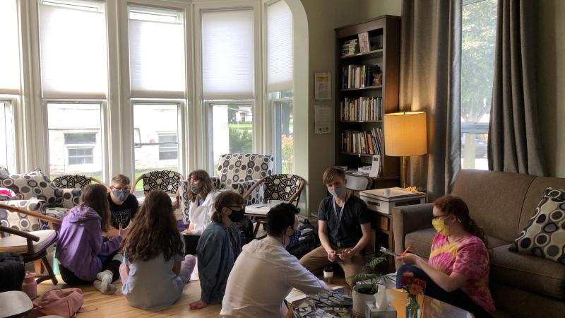 Several students in masks in living room.