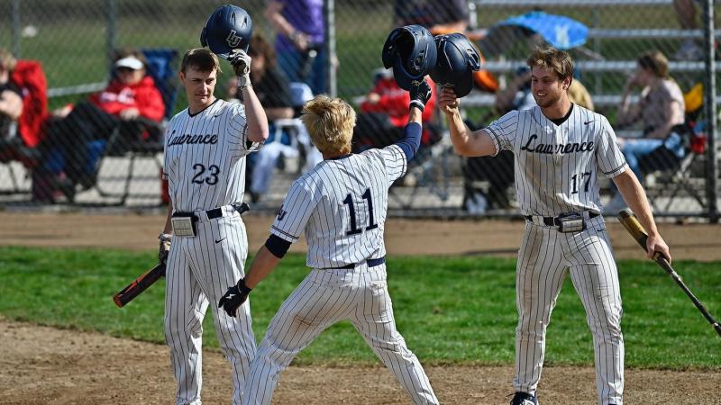 Lawrence outfields celebrate together on the field.
