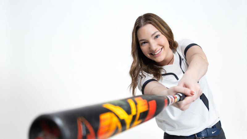 Mattigan Haller swings a softball bat during a media day photo shoot.
