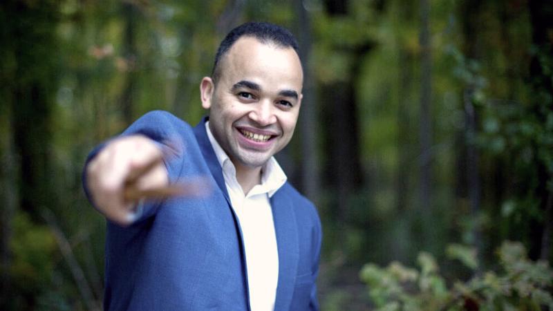Jean Carlo Ureña Gonzalez standing in woods and pointing at viewer with drum sticks