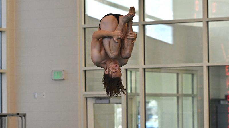 Jackson Bertman tucks in his knees in mid-dive.
